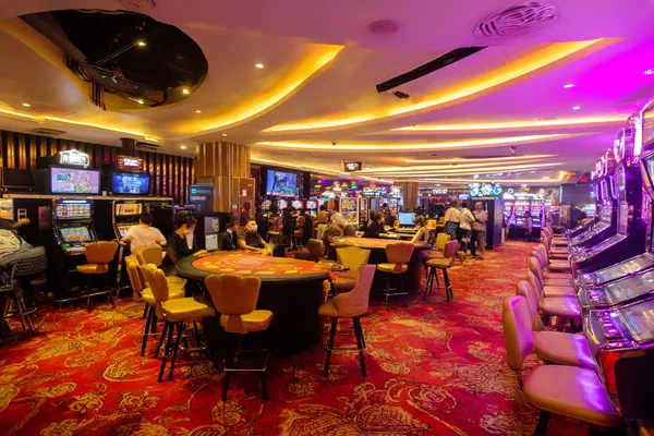 9777BED App — Enjoy seamless gaming on your smartphone A young woman relaxing with her phone while dynamic casino elements float around her, illustrating the smooth mobile experience offered by the 9777BED app.