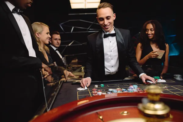 A woman in a luxurious green gown next to an ornate roulette wheel, capturing the upscale casino mood of 9777BED.